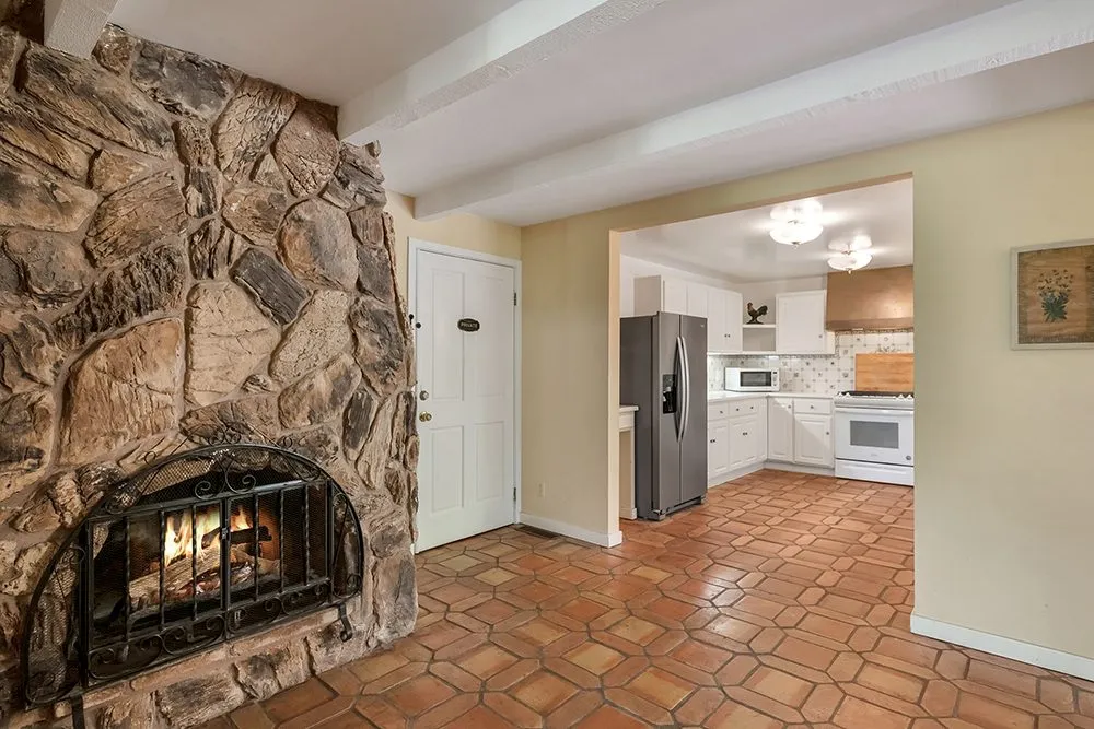 A stone fireplace beside the full kitchen of The Grand Residence