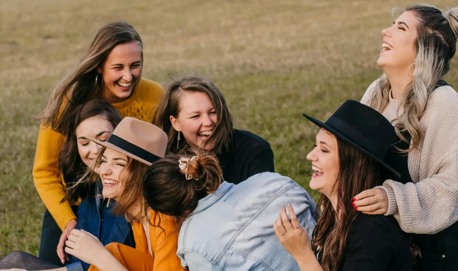 A group of friends laughing together on the lawn