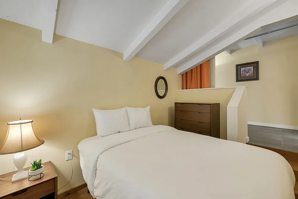 A Hillside Room with a king bed under a white-beamed ceiling